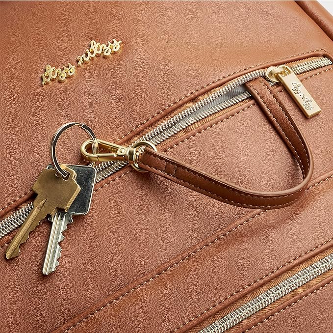 Itzy Ritzy Eras Diaper Bag Backpack – Large Capacity Backpack Diaper Bag Featuring Sleek Design, 15 Pockets, Changing Pad, Stroller Straps, and Luggage Sleeve (Cognac)